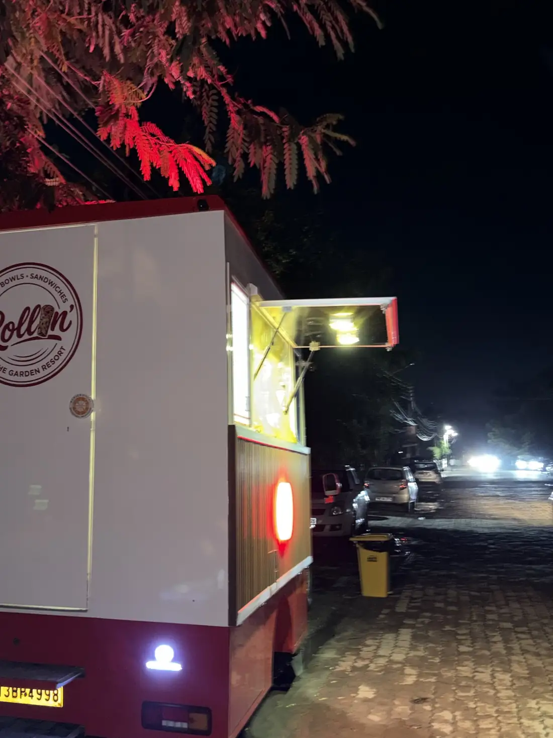 The Rollin' truck at night with its service window open and lit